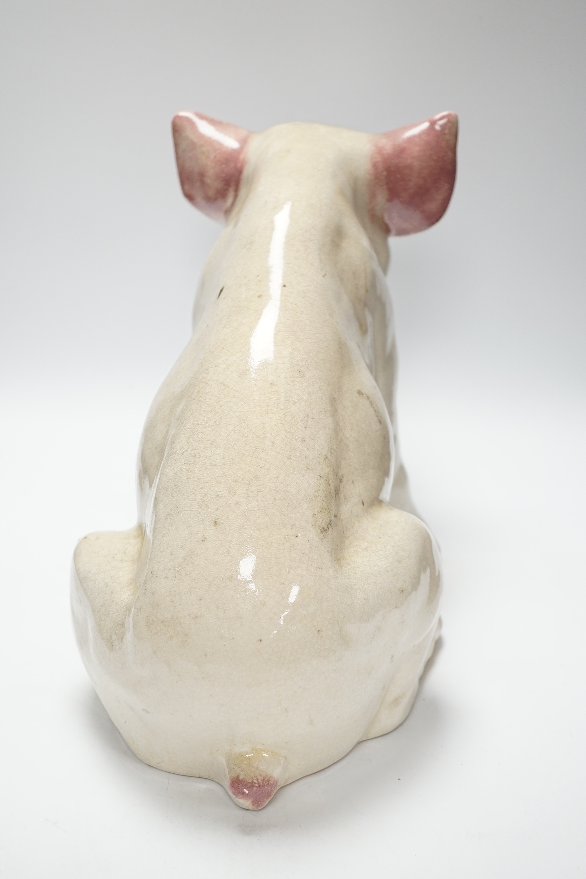 A large earthenware model of a seated piglet, 31cm high
